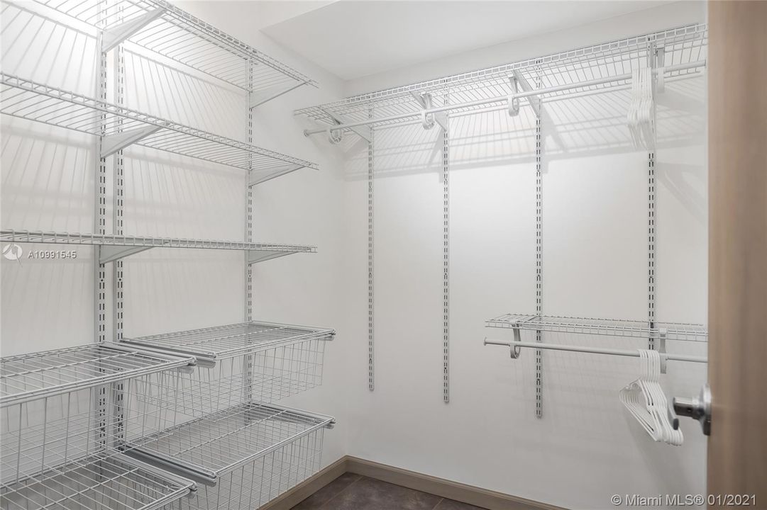 Walk in closet with adjustable storage units.