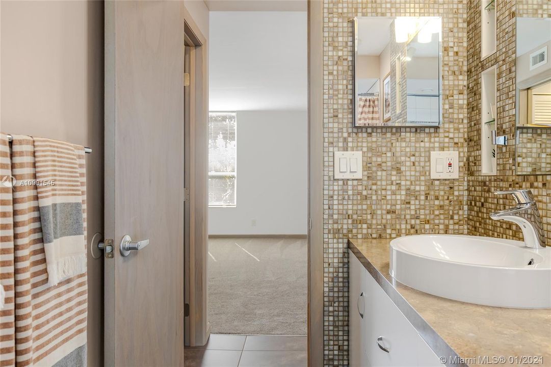 Bathroom view custom vanity, walled storage areas.