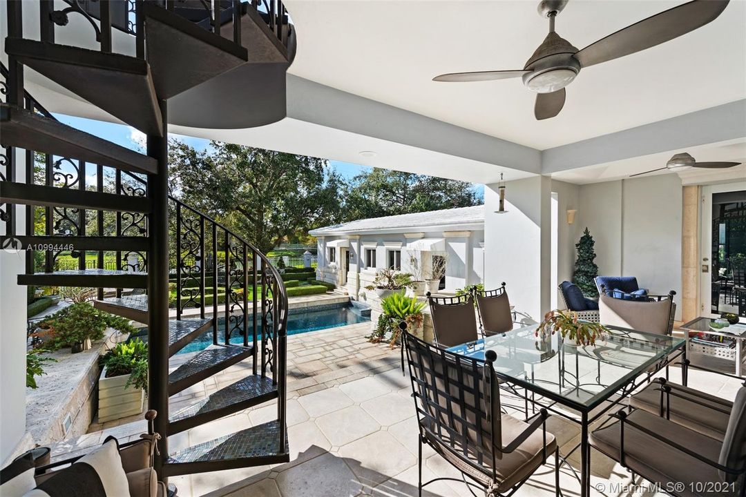 Terrace off of living room overlooking pool/ golf course. Stairs leading to Master bedroom balcony