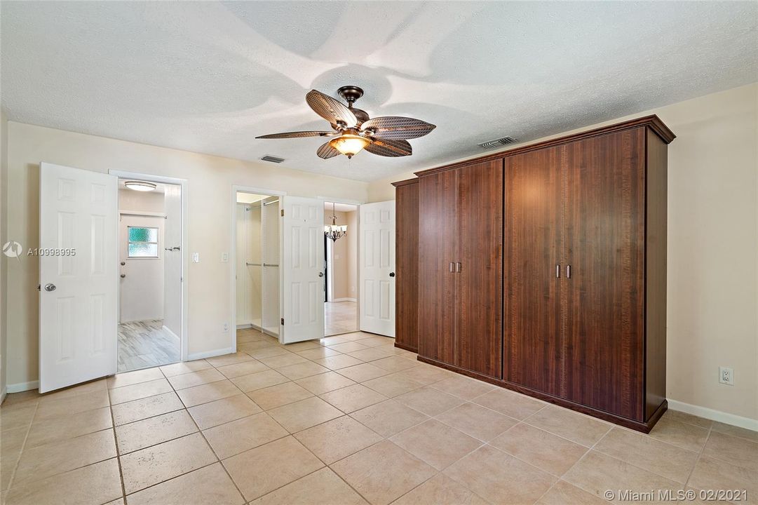 Master bedroom with a storage cabinet and a walk-in closet. Private bathroom.