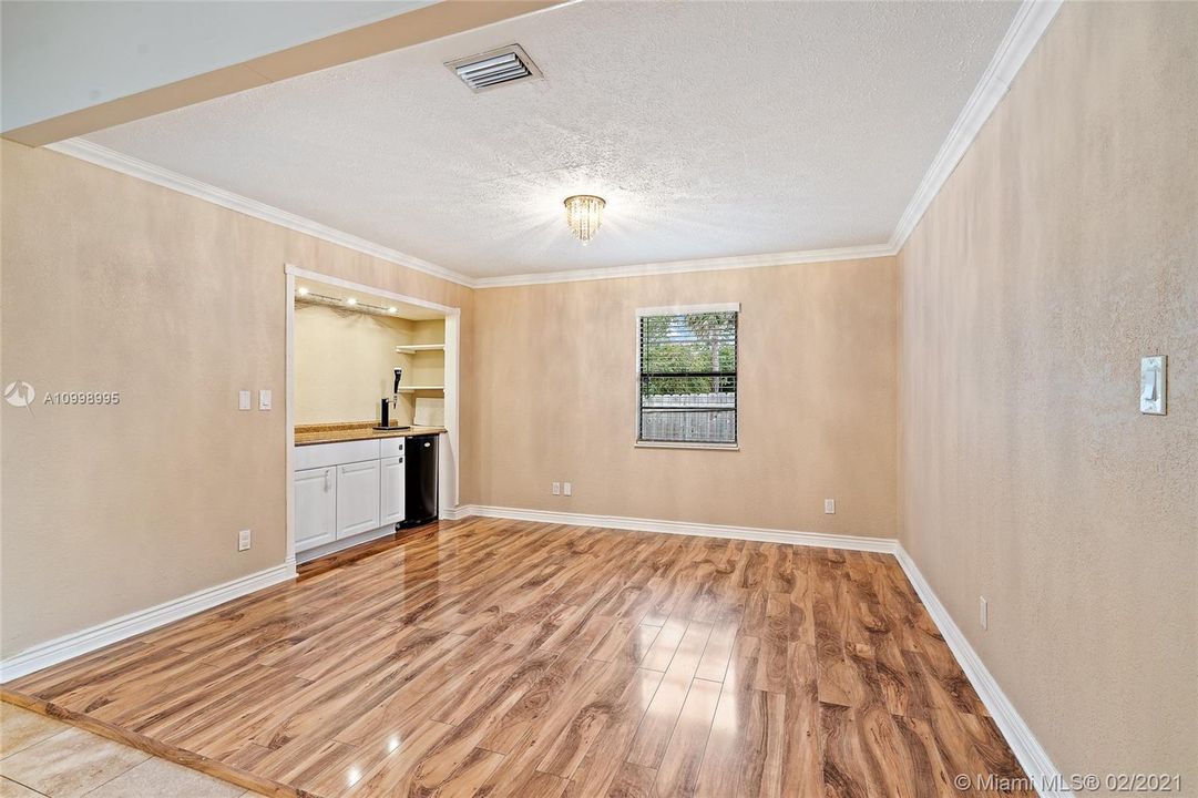 Den /family room with bar area with extra storage and wood floor.