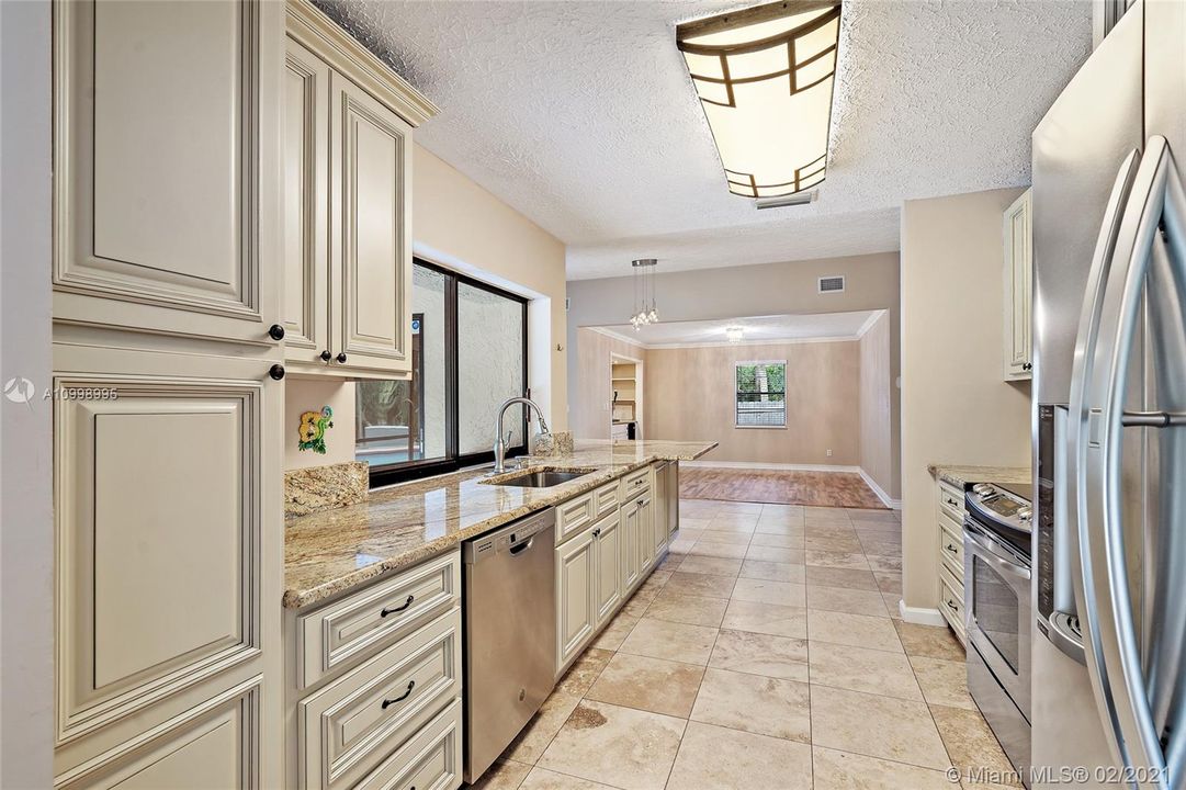 Kitchen with sliding glass window pass through to screeened in lanai.