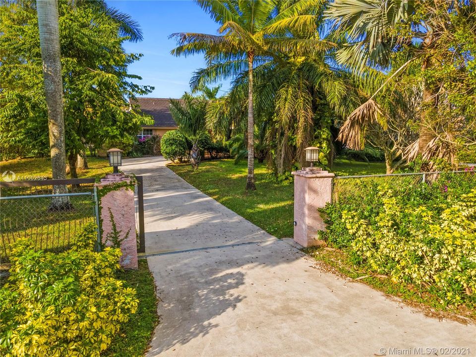 Driveway view front entrance lushly landscaped.