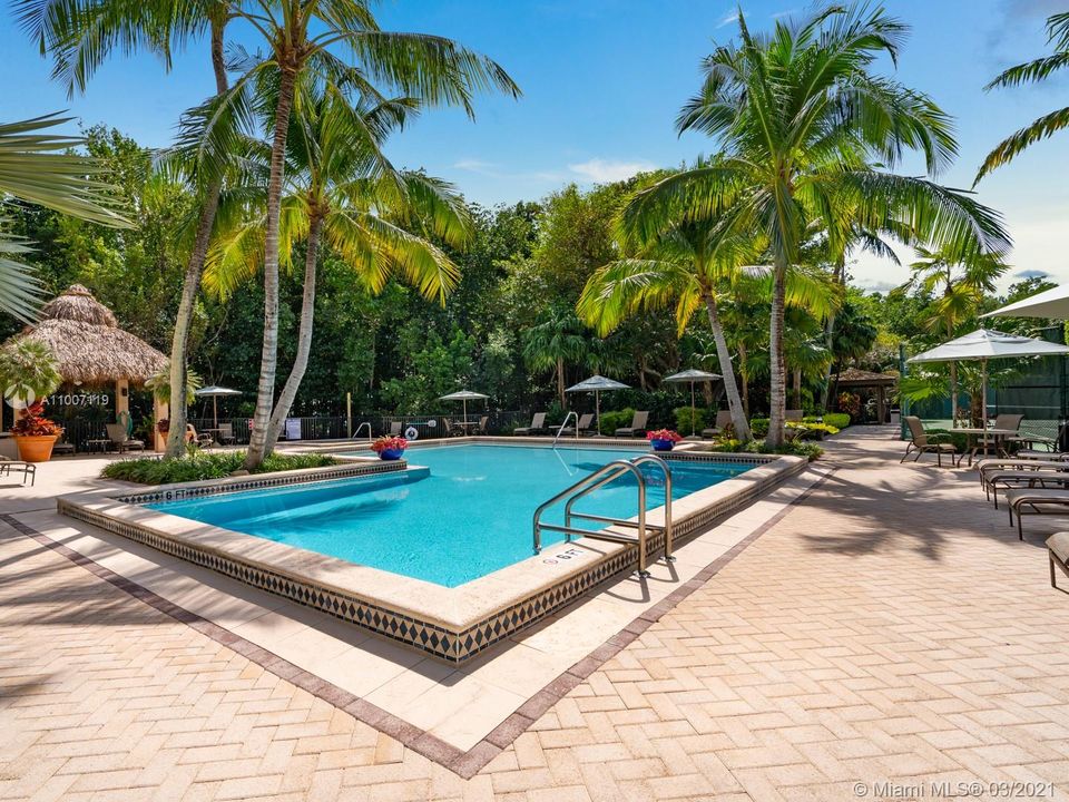 The community pool & hot tub. Nearby is one of the tennis courts and the clubhouse, manager's office, fitness room & bathrooms.