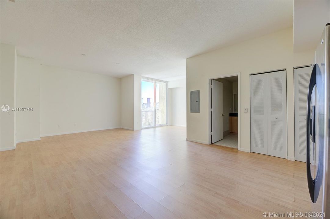 Spacious studio with wood floors, 10 foot high ceilings, balcony with view to downtown and overlooking community pool