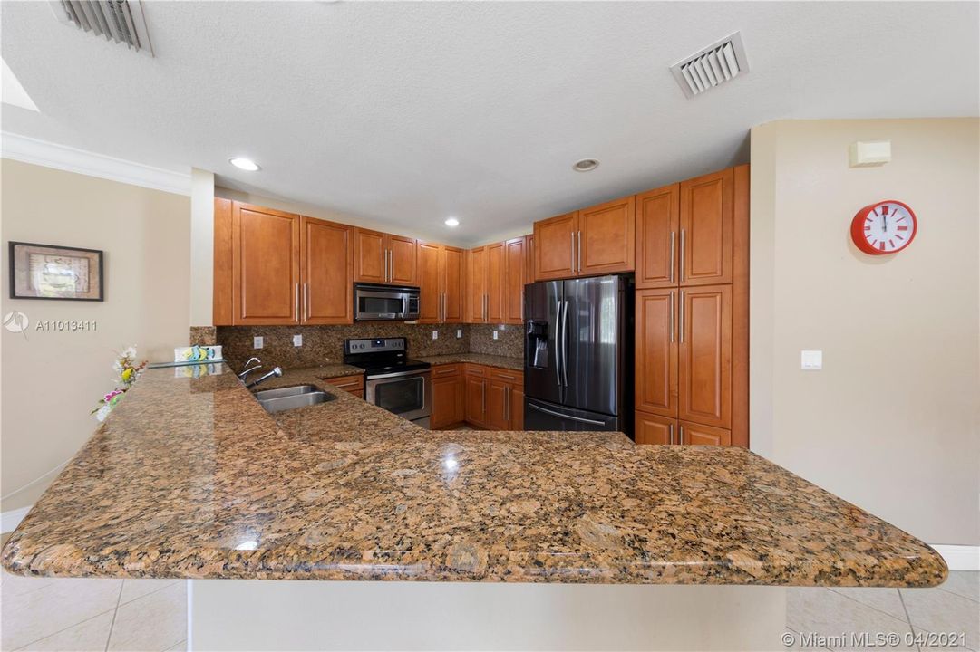 LARGE KITCHEN OVERLOOKING FAMILY ROOM W/ GRANITE COUNTER TOPS, STAINLESS APPLIANCES, AND PANTRY
