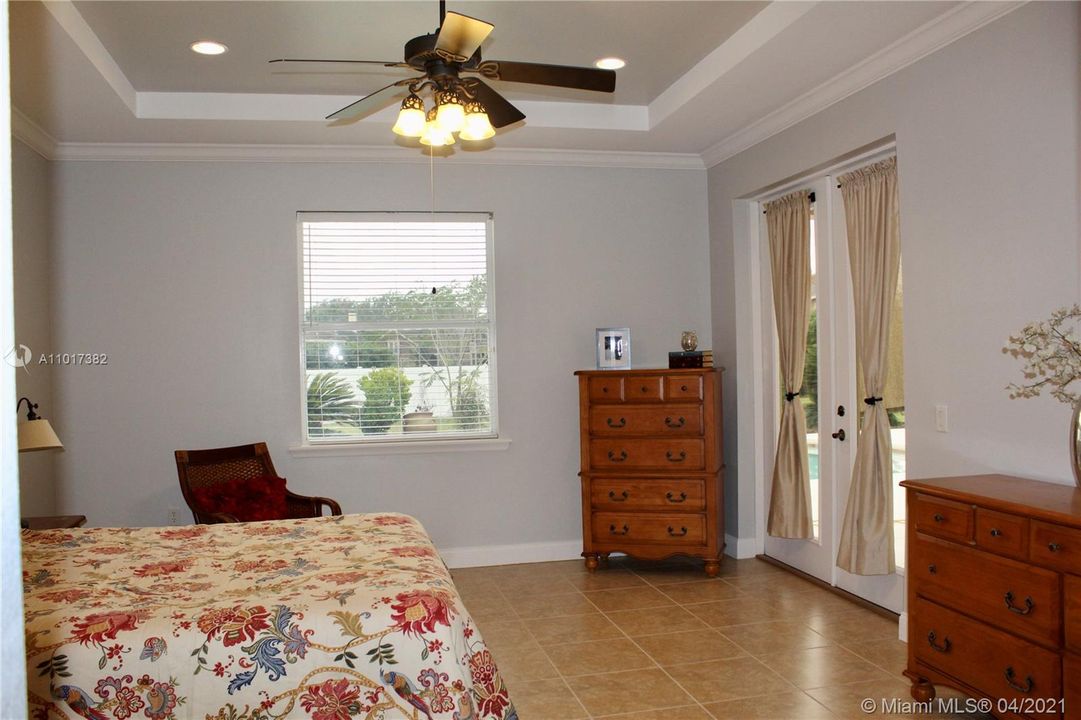 Master bedroom with French doors opening to the pool area