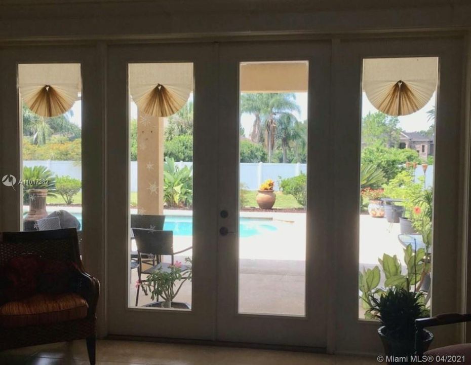 Living room's French doors open to the pool area.