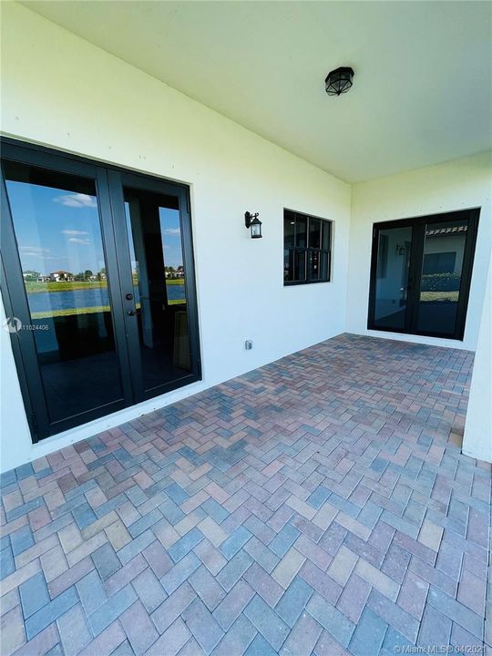 Two sets of french doors leading to patio area.