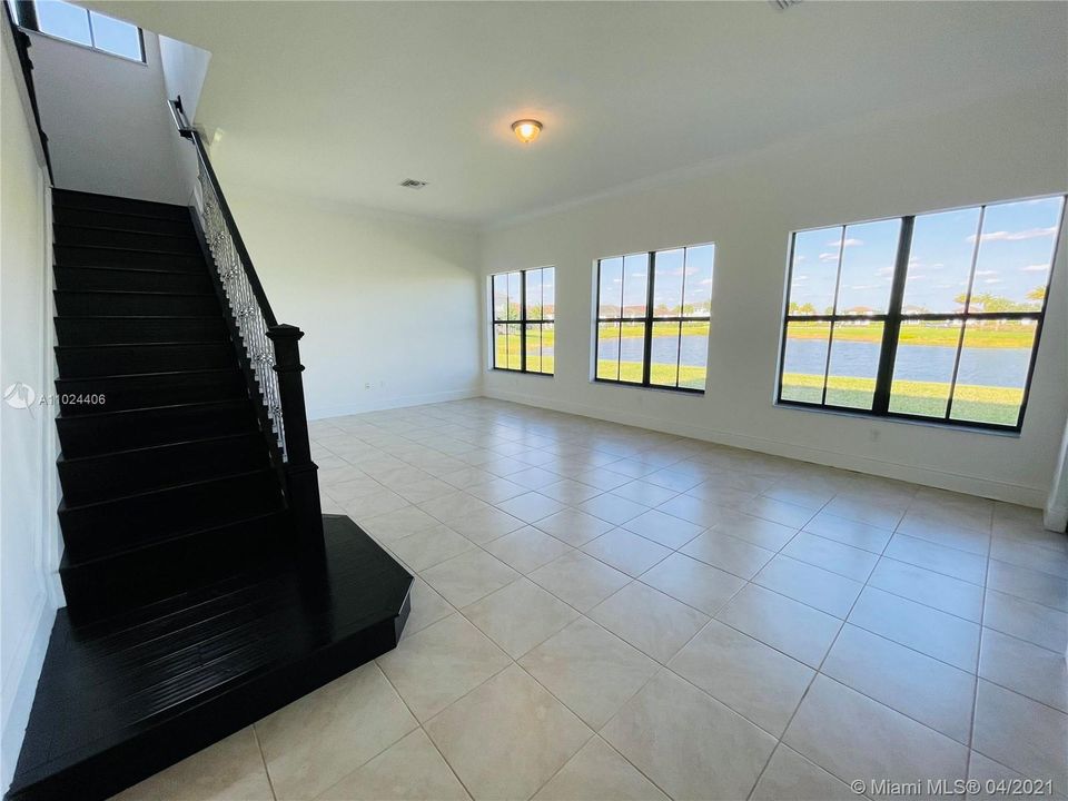 Family room includes large windows with a beautiful view of the lake and large backyard. Stairs leading to second floor have been upgraded to wood.