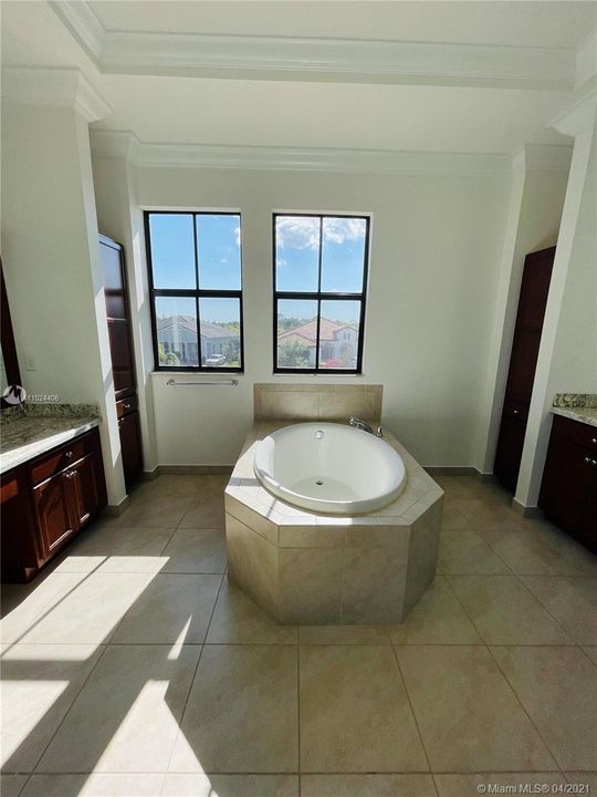 Second entry to master bathroom features roman tub, one large vanity space, and one large sink space, both of these on opposite sides.