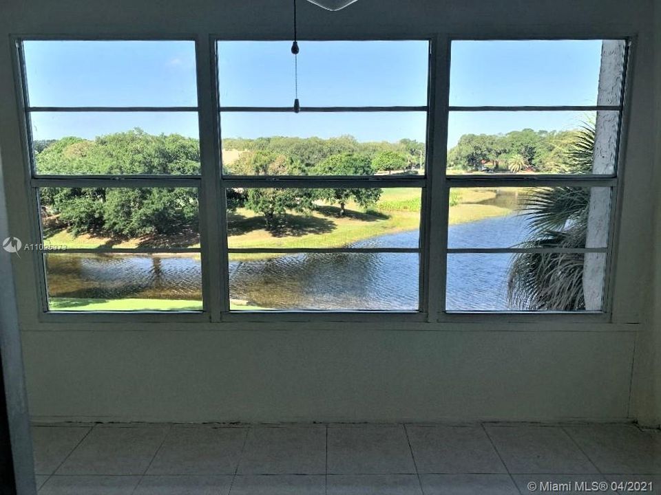 ENCLOSED PORCH OVERLOOKS SPECTACULAR VIEW OF LAKE AND GOLF COURSE.