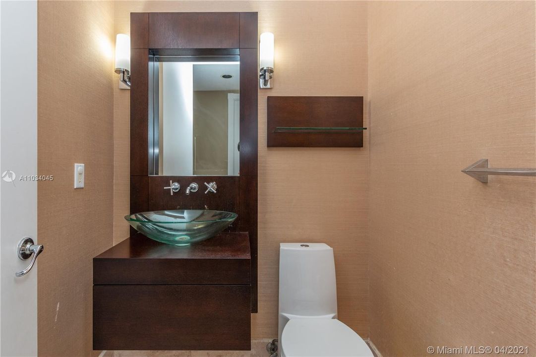Half bath located downstairs with an additional bath situated across from the downstairs room