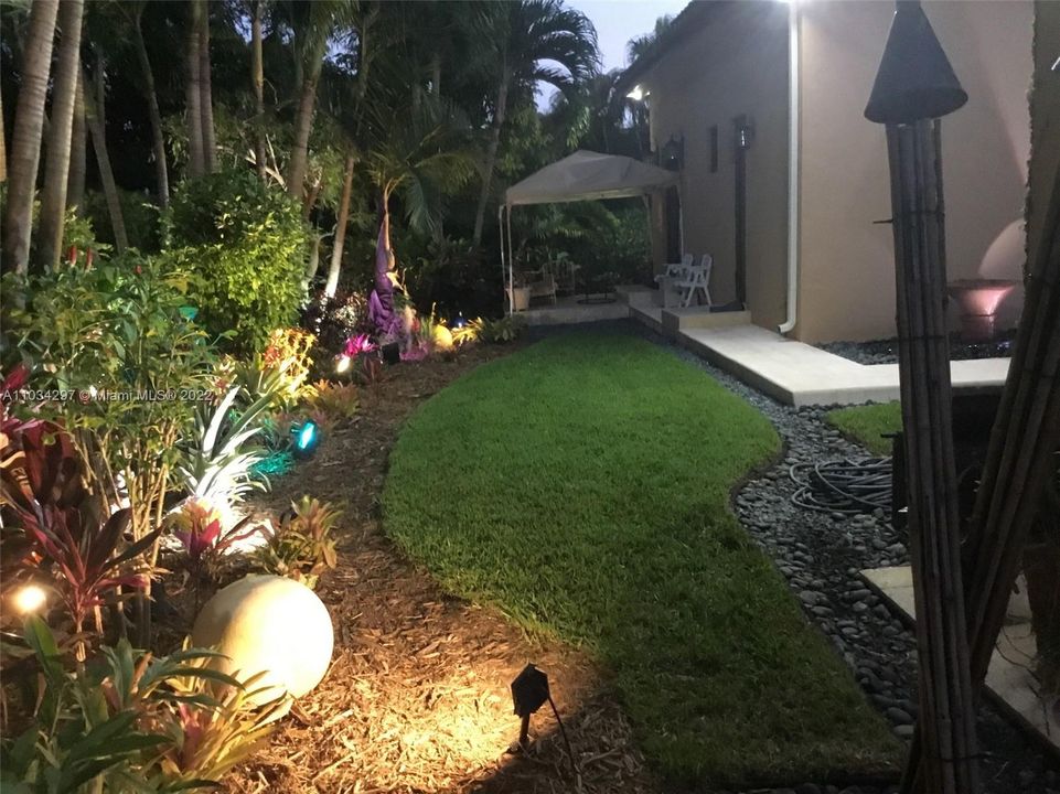 Backyard with lighted landscaping and Cabana on the right