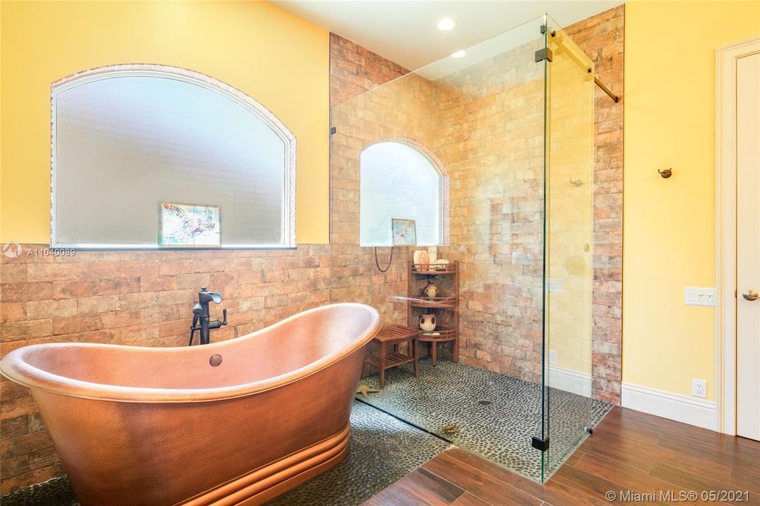 Downstairs bath suite featuring stand alone shower soaking tub.