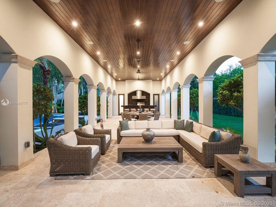 Magnificent outdoor living room with full summer kitchen, dining table and living area with TV is perfect for entertaining.