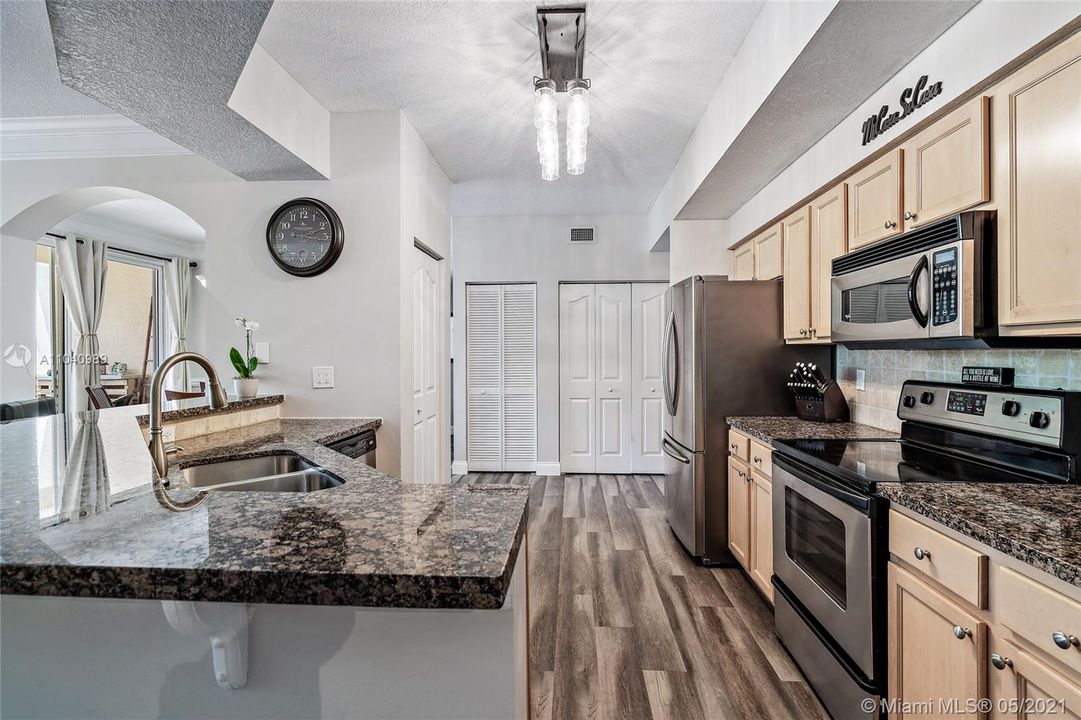 Kitchen with granite countertops and stainless steel appliances. Laundry closet, pantry closet and utilies closet.