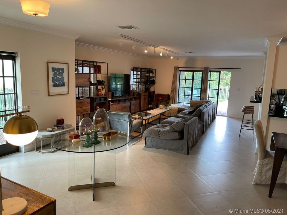 Living room area with the kitchen to the right and the patio and dock beyond.