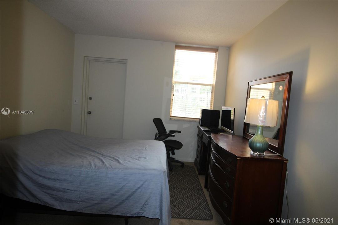 Bedroom, door to screened-in patio. Room for a desk/workspace with garden view.