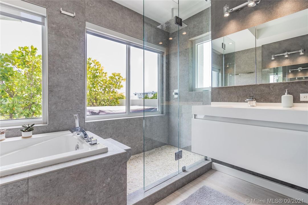 Large en-suite bath with separate tub and shower and large east facing windows overlooking private patio.