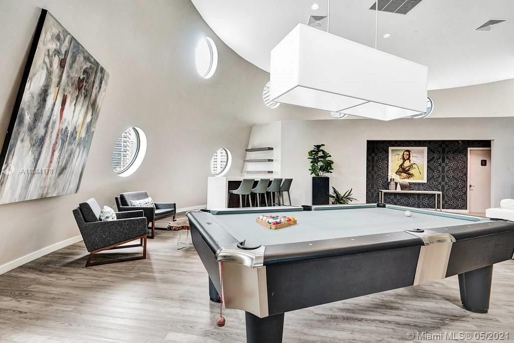 State-of-the-art recreational room with a pool table and sophisticated natural light throughout