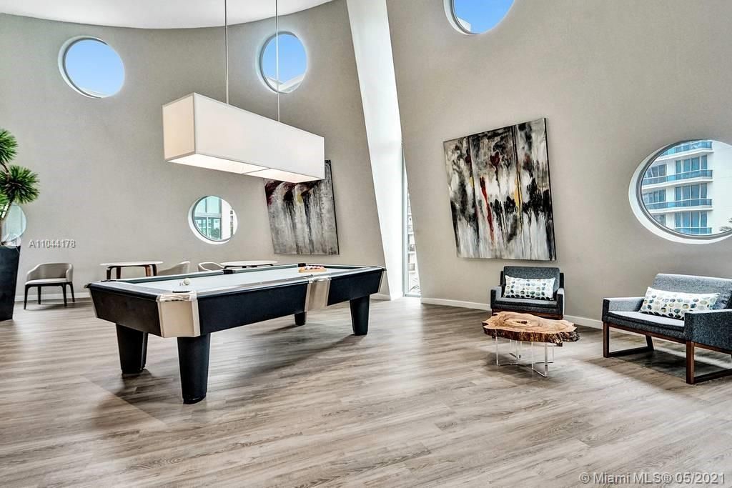 State-of-the art recreation room with a pool table and designer furniture