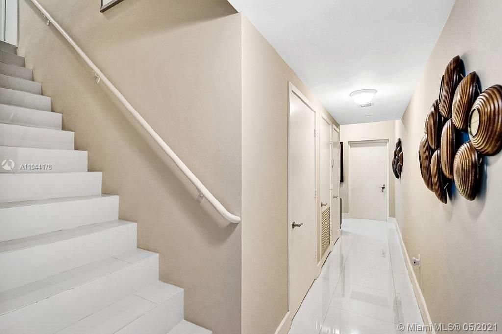 A staircase leading to Master Bedroom and Loft/Den upstairs. On the right, there is a foyer with a main entrance to the apartment.