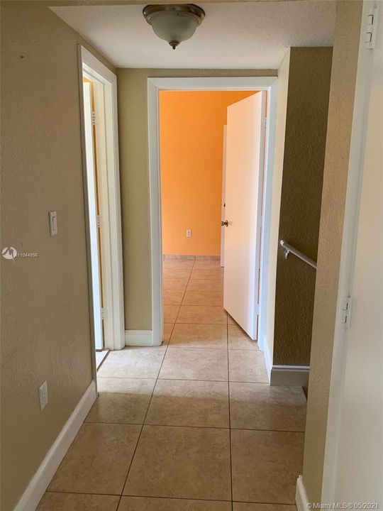 Upstairs hallway connecting the beds and baths with staircase to the right.