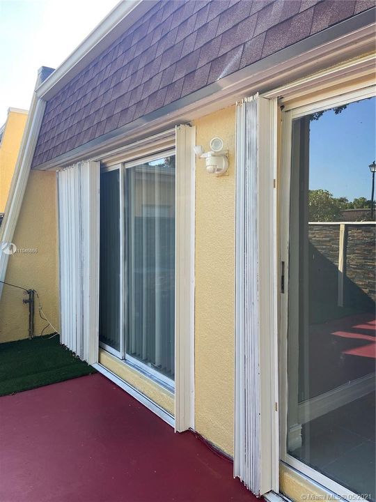 Three sets of sliding glass doors with according shutters.