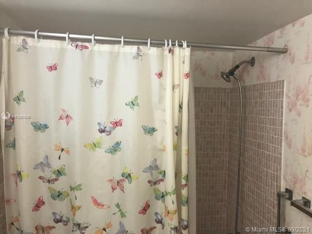 closer look at the tile in bathroom with wall paper.  combo TUB Shower