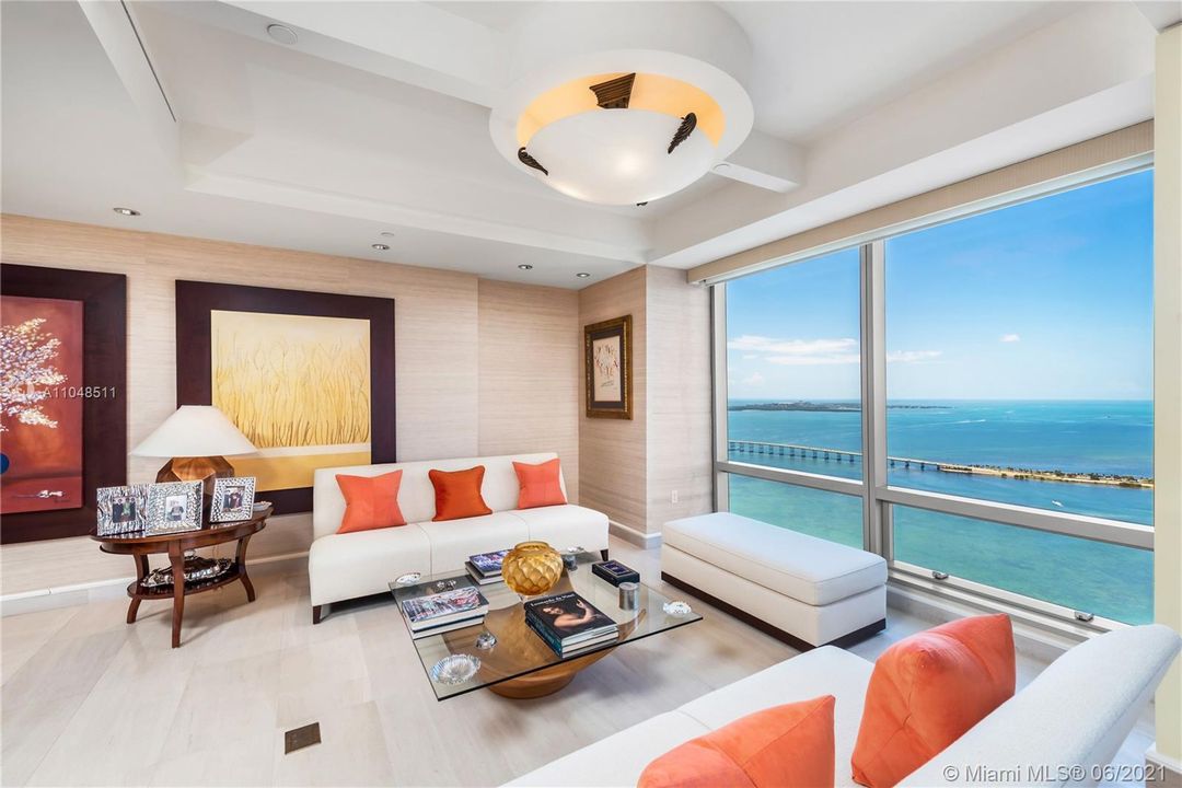 Living room with panoramic Biscayne Bay views from its floor to ceiling windows.
