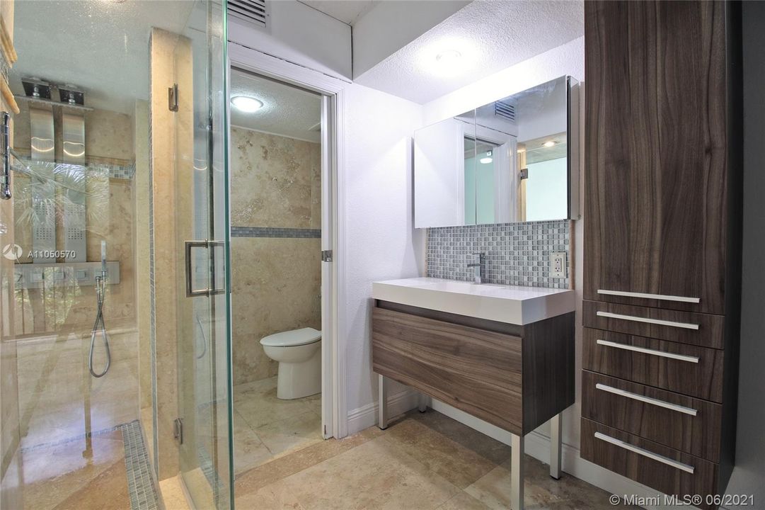 Beautiful master bathroom with marble floors and walls and rain shower.