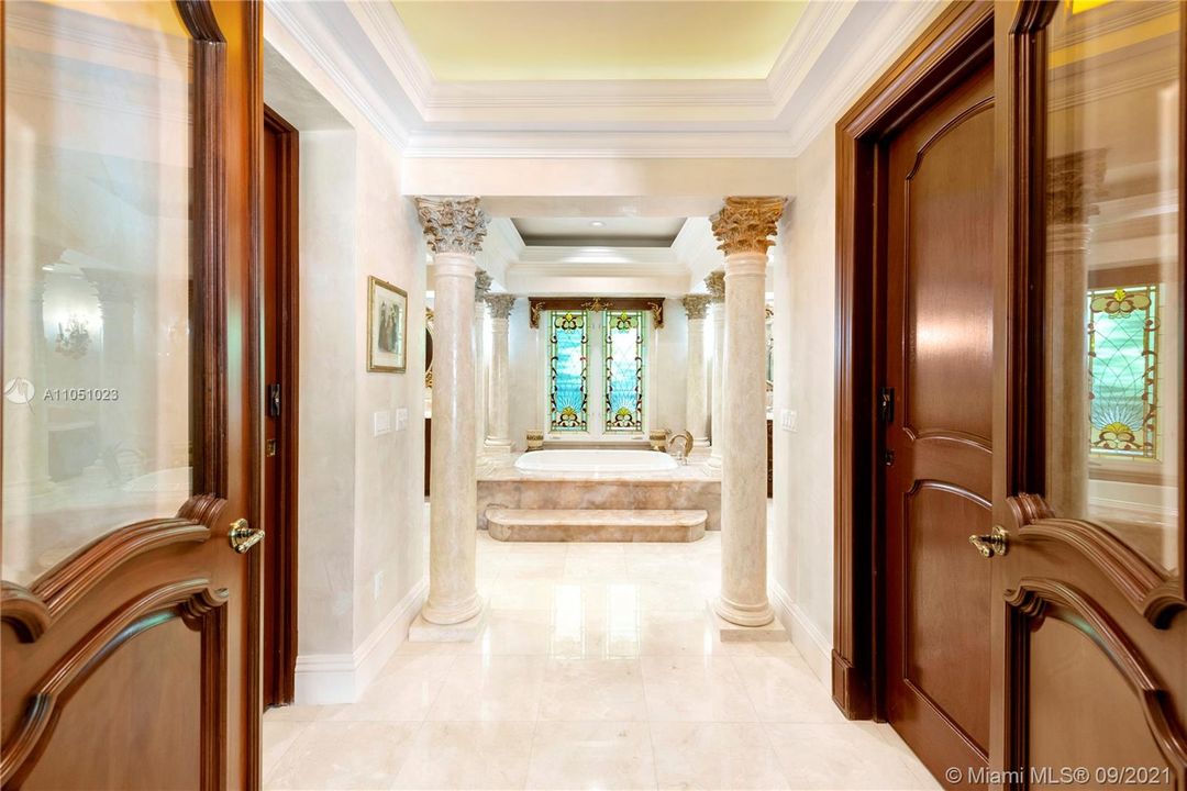 entrance to the Masterbathroom suite from the bedroom with his and her walk in closet to the left and right.