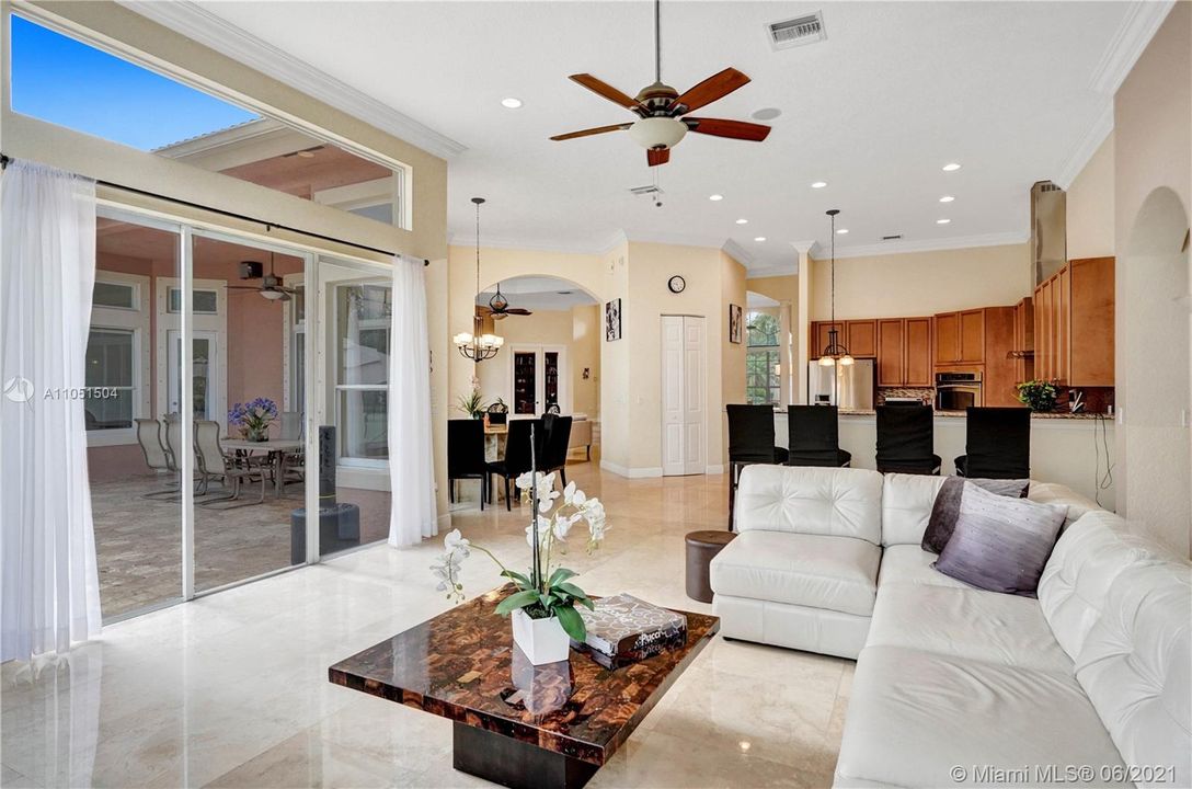 Majestic family room with marble floors  and huge windows, overlooking the pool area