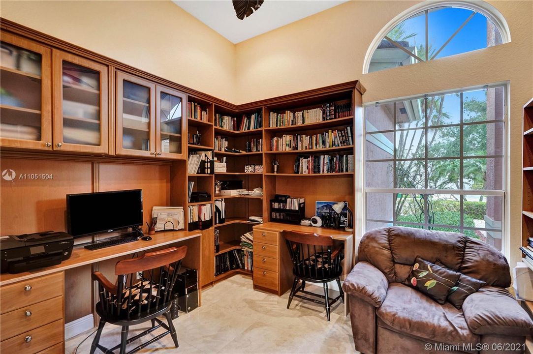 Sumptuous library room with beautiful wood cabinetry and shelves, custom shaped windows sets the mood for a peaceful reading time