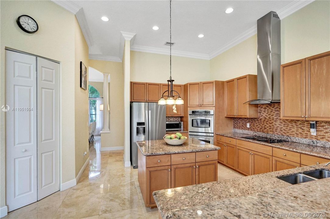 Beautiful gourmet kitchen with granite countertops, marble floors and wood cabinetry