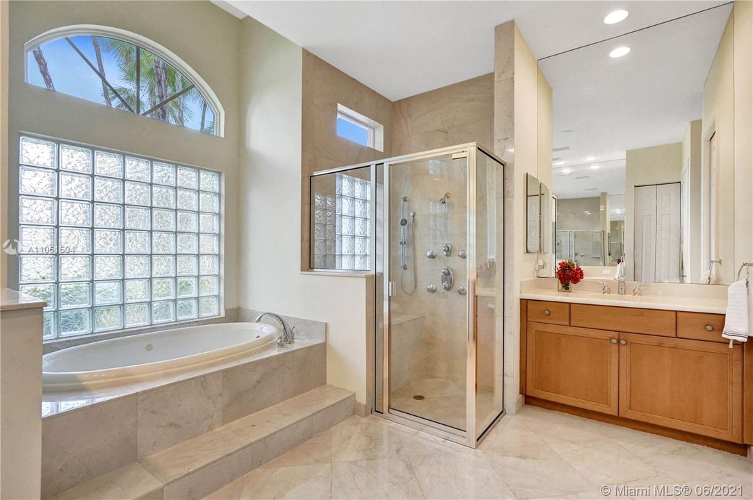 Marvelous, very spacious marble Master Bathroom with custom shaped windows and window cabinetry