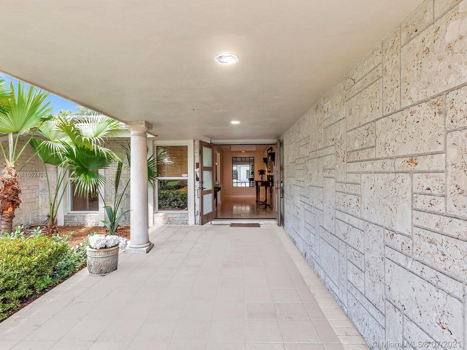 SPECTACULAR COVERED FRONT ENTRANCE FEATURES NATURAL STONE, GREENERY AND WOOD GIVING THIS HOME A CONTEMPORARY LOOK...
