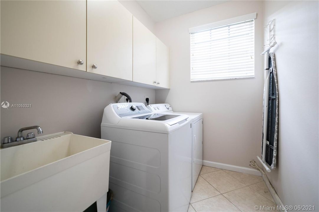 laundry room  with cabinet and washing tank