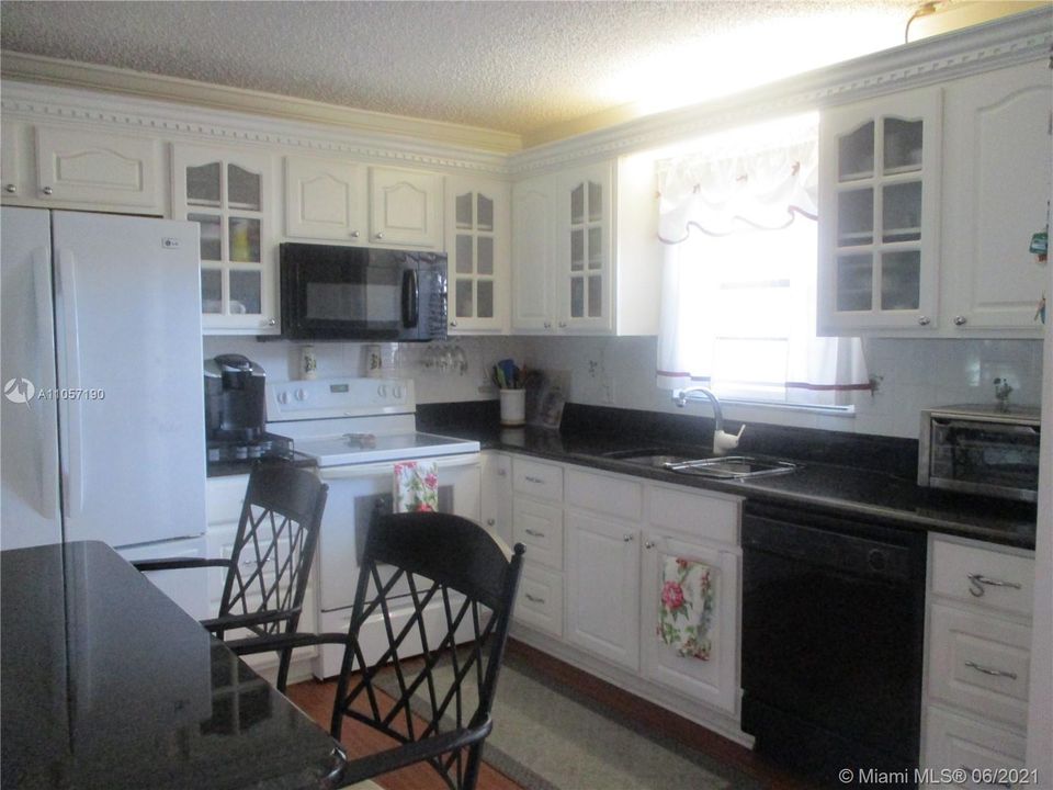 Granite counter top with beautiful white cabinets & appliances