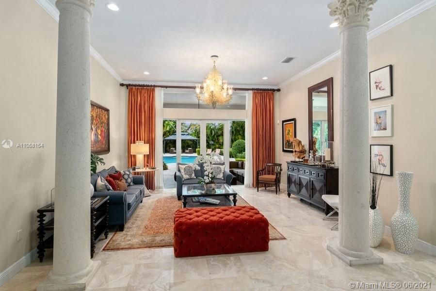 Formal living room welcomes you with a tall ceilings and view of the inviting and setback pool.