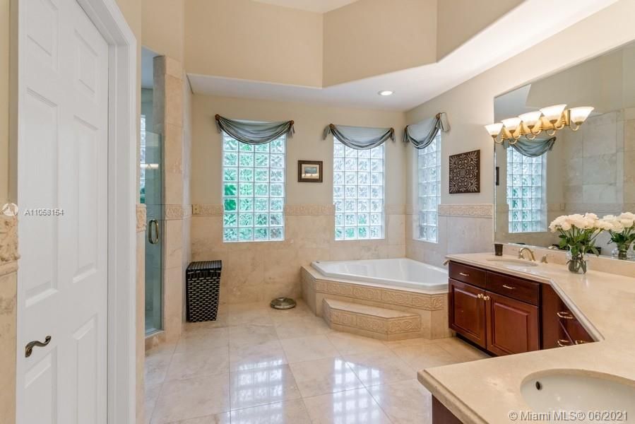 Master bathroom suite features jacuzzi and enclosed showers and two sinks.