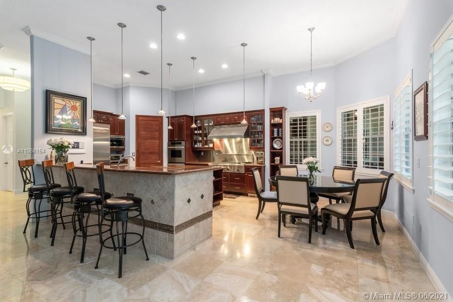 Large open kitchen features tall ceilings, oversized gas Thermador stove top and breakfast area.