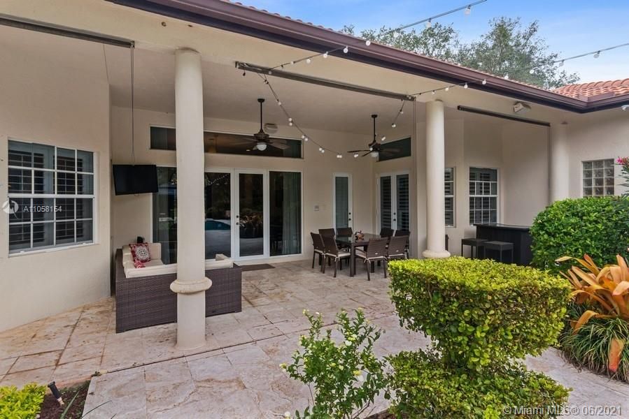 Covered patio area overlooks pool and massive backyard.