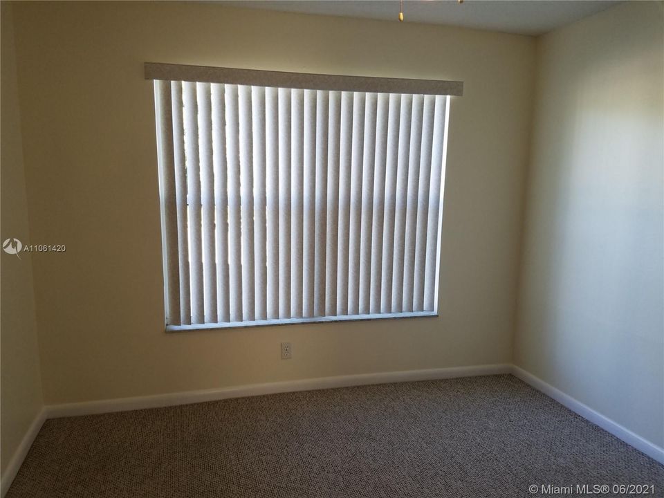 Second bedroom is carpeted and has a paddle fan.