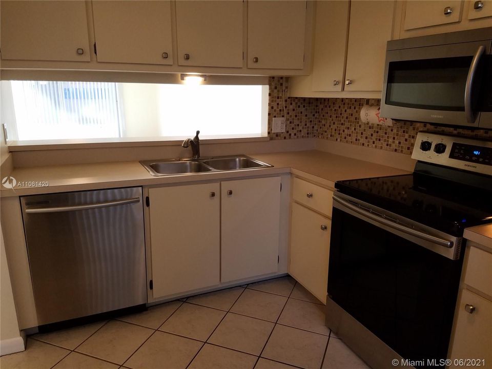 Newer stainless steel appliances in the kitchen. Pass through to dining area.