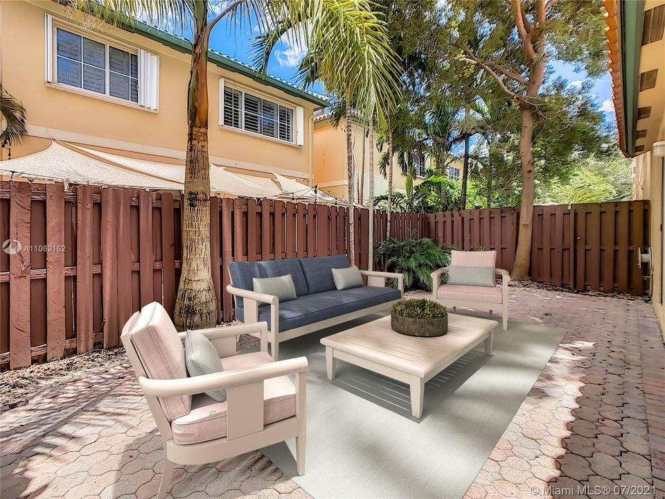 Fenced trendy back paver patio that looks beautiful. (“Virtual Staging”)