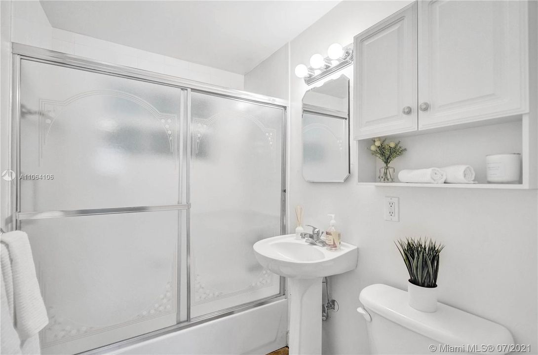 Sparkling white, pedestal sink & cabinets exude the perfect blend of functionality & beauty