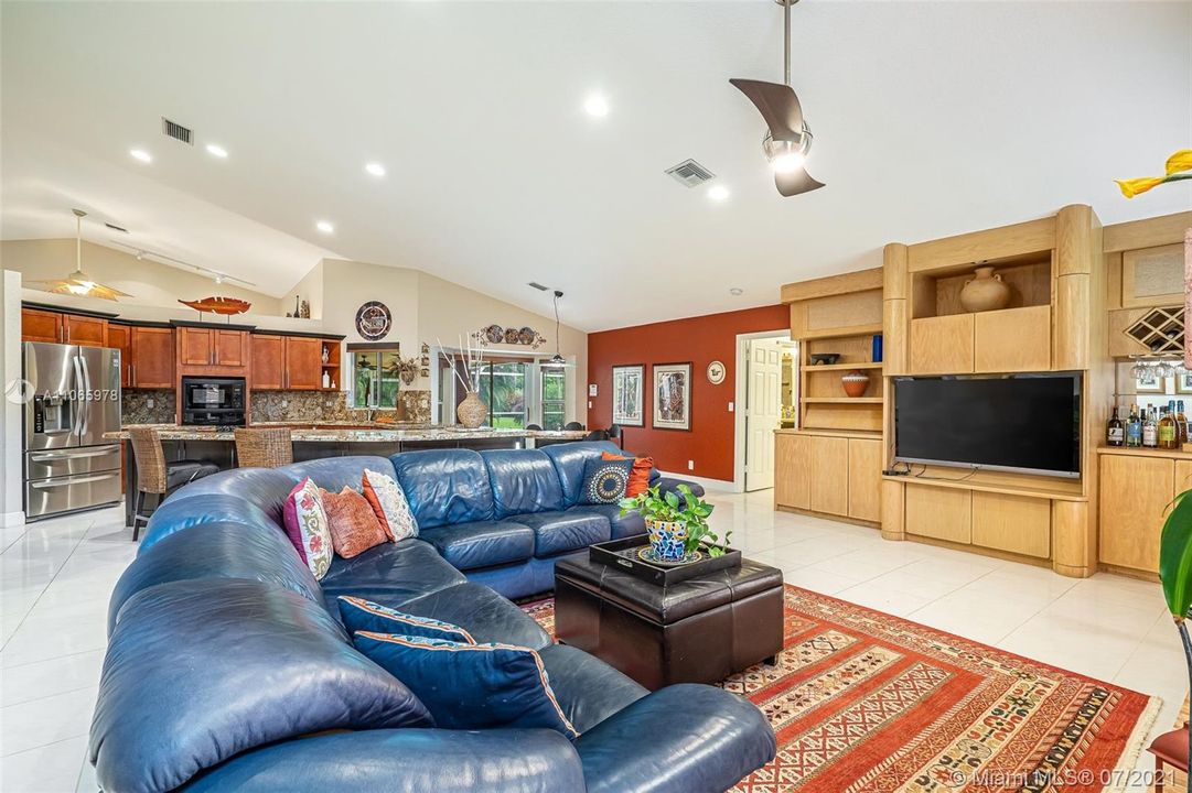 Large family room open to kitchen area complete with custom built in, wet bar & wood burning fireplace