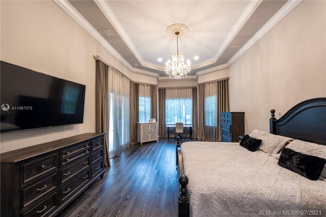 Master Suite with wood flooring, coffered ceiling, and electric automated window treatments